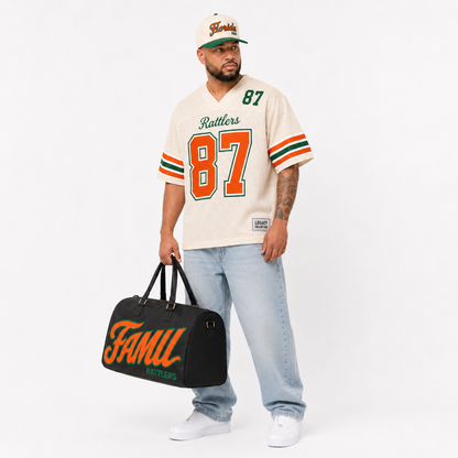 FAMU Legacy Jersey male campaign image in cream jersey with FAMU cap and travel bag