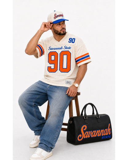 Savannah State travel bag with cream jersey seated studio view