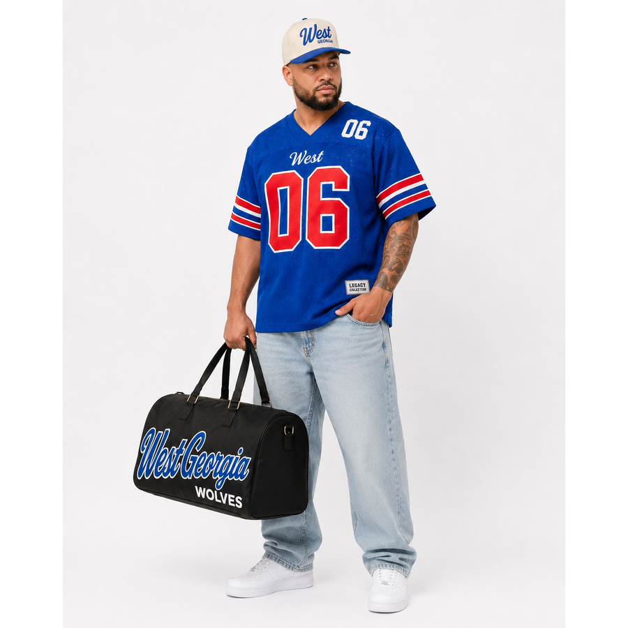 West Georgia Legacy Campus Collection male campaign model wearing West Georgia jersey and cap with travel bag alternate view